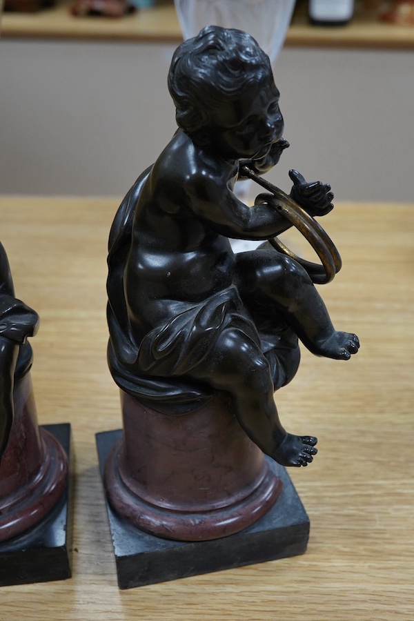 A pair of 19th century French bronze figures of children playing instruments, raised on rouge marble columns, 23cm high. Condition - poor